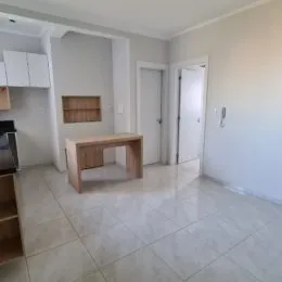Ambiente interno com piso de cerâmica e móveis de madeira clara.