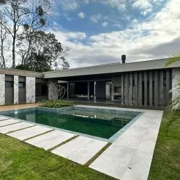 Piscina externa com deck e gramado em uma propriedade em Lajeado.