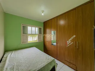Quarto com armário de madeira e janela com venezianas na Lajeado.