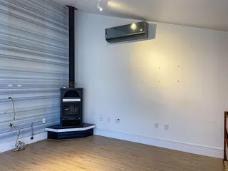 Sala com lareira e piso de madeira clara.