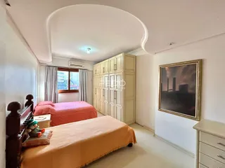 Quarto com cama e armários em um ambiente claro.