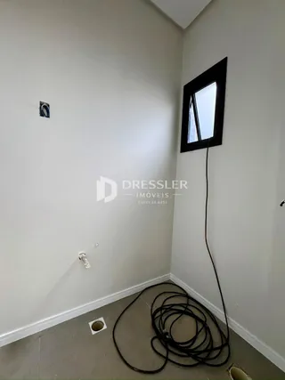 Vista de um corredor interno com paredes brancas.