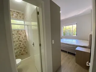 Vista de um corredor interno com porta de vidro em um imóvel em Lajeado.