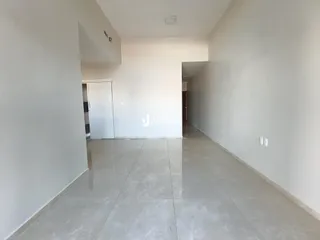 Hall de entrada com paredes brancas e piso claro.