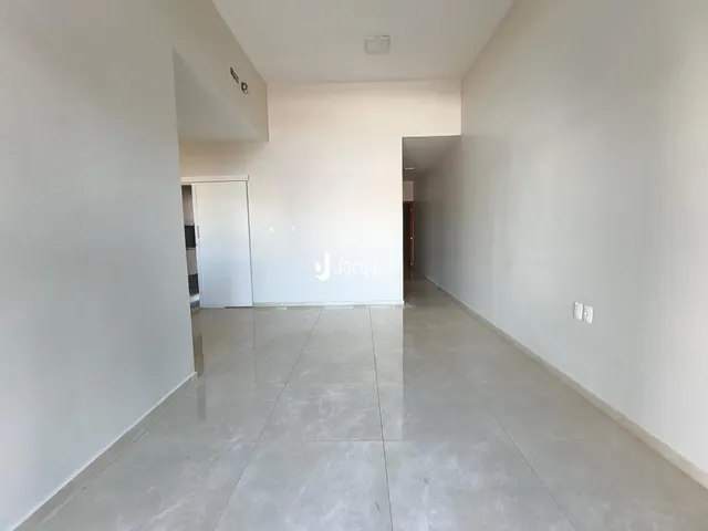 Hall de entrada com paredes brancas e piso claro.