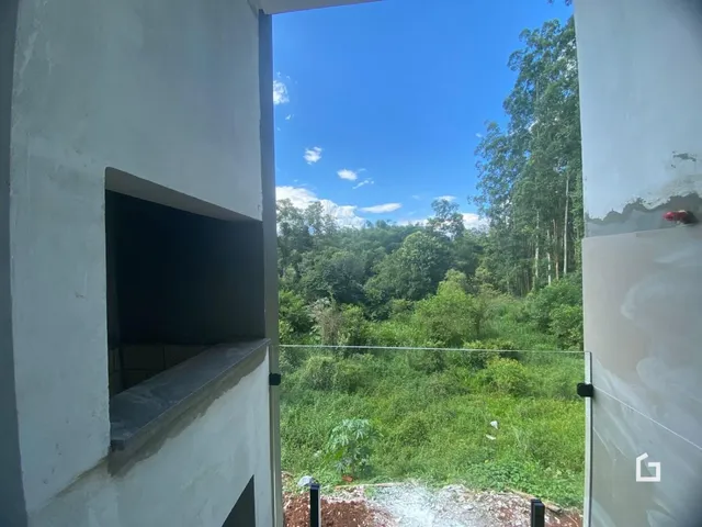 Vista de uma abertura interna para uma área verde exuberante.