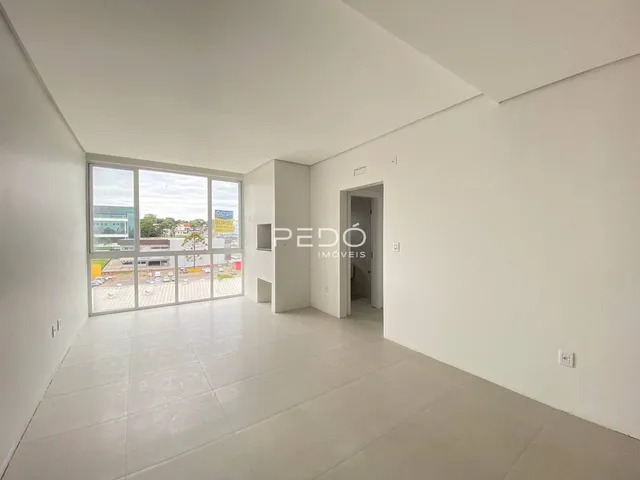 Ambiente interno de uma sala ampla com piso de cerâmica e grande janela.