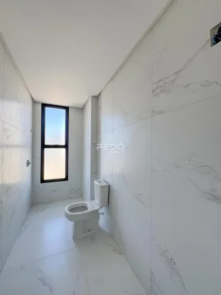 Foto de um banheiro moderno com paredes brancas e piso claro.