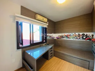 Ambiente interno de uma sala com revestimento de madeira e janela.