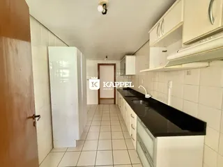 Esta é uma foto de uma cozinha com armários brancos e piso de cerâmica.