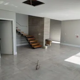 Ambiente interno com escadas e piso de concreto.