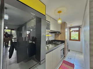Vista da cozinha com armários brancos e bancada de granito.