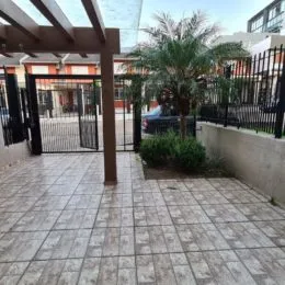 Foto de uma área externa pavimentada com piso de cerâmica e estrutura de madeira.