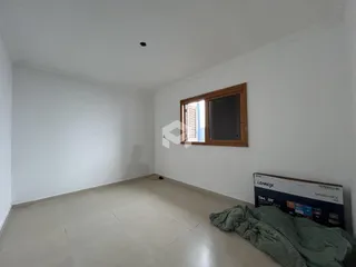 Ambiente interno de uma sala com paredes brancas e piso de cerâmica.