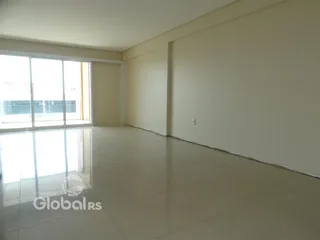 Sala de estar com grande porta de vidro e piso claro.