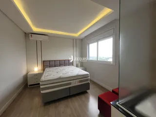 Quarto com cama e janela em um apartamento moderno.