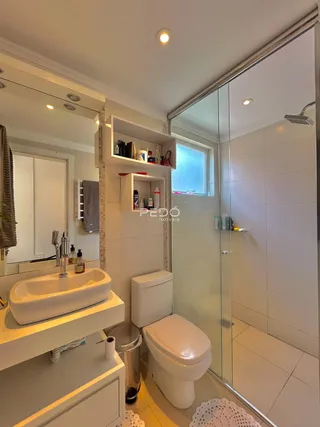 Foto de um banheiro moderno com box de vidro e bancada branca.