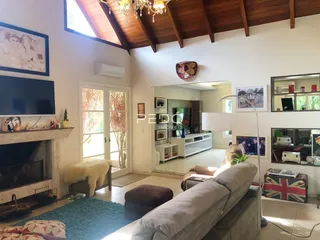 Sala de estar com lareira e grandes janelas em um imóvel no Brasil.