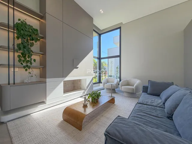 Sala de estar moderna com grande janela e decoração neutra.