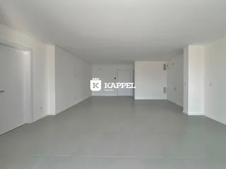 Um corredor interno de uma residência com paredes brancas e piso cinza.