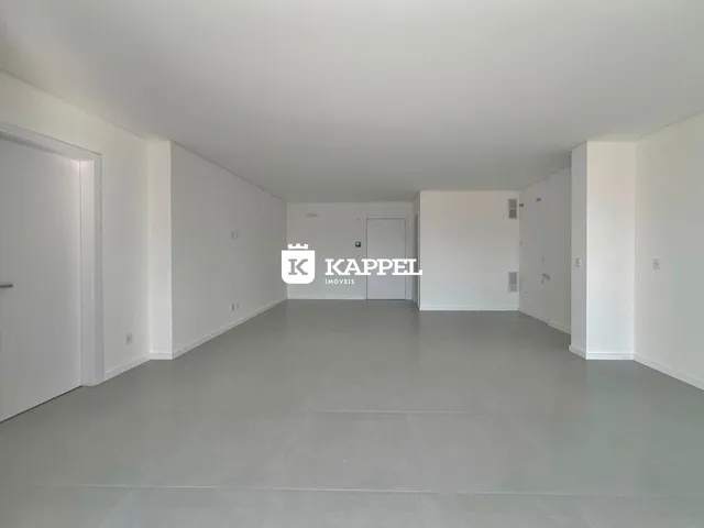 Um corredor interno de uma residência com paredes brancas e piso cinza.