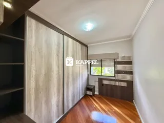 Um quarto com armários de madeira clara e piso de madeira polida.