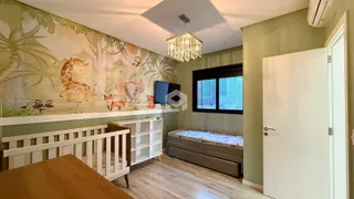 Quarto com decoração de mural de animais e piso de madeira.