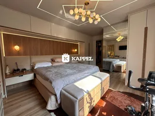 Quarto moderno com cama grande e painéis de madeira na decoração.