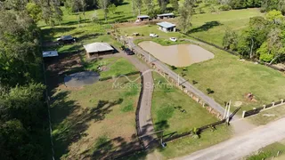 Vista aérea de uma propriedade rural com área verde e um lago.