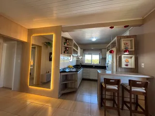 Ambiente de sala de estar e cozinha em um imóvel no Brasil.