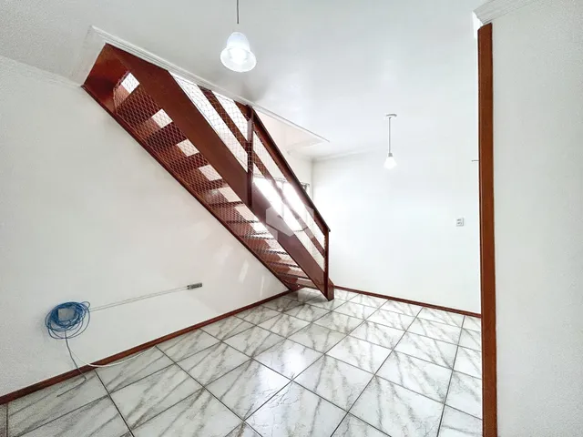 Hall com piso de cerâmica claro e parede branca.
