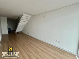 Ambiente interno de uma residência com piso de madeira e escadaria.