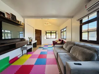 Sala de estar com sofá e piso colorido em Lajeado.