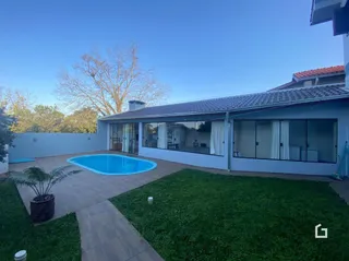 Vista da área externa com piscina e jardim de uma propriedade em Lajeado.