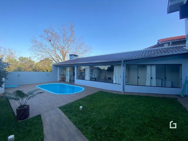 Vista da área externa com piscina e jardim de uma propriedade em Lajeado.