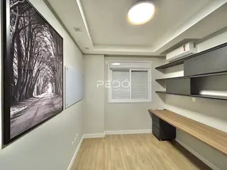 Interior de uma sala com parede decorada e estantes de madeira.