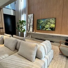 Sala de estar com sofá e painéis de madeira na residência.