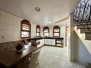 Sala de jantar e cozinha com piso de cerâmica e janelas.