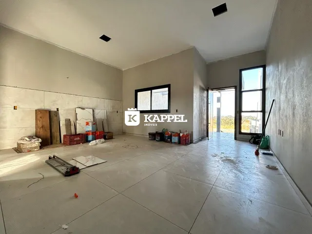 Sala ampla e vazia com materiais de construção no interior da residência.