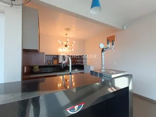 Foto da cozinha moderna com bancada escura e pia de inox.
