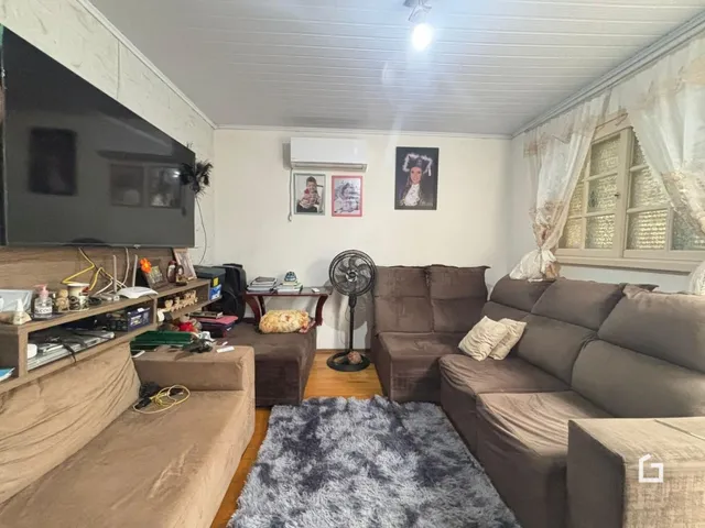 Sala de estar com sofá e televisão em um imóvel no Brasil.