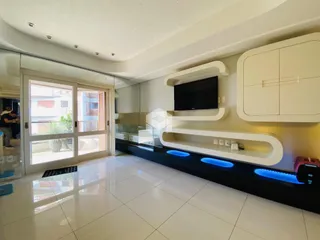 Sala de estar moderna com piso de porcelanato claro e móveis embutidos.