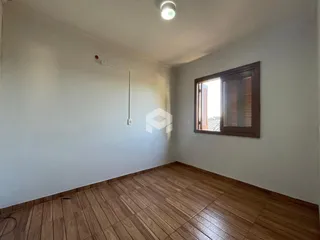 Ambiente interno com piso de madeira e janela.