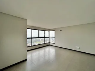 Ambiente interno amplo com grandes janelas que oferecem uma vista da cidade.