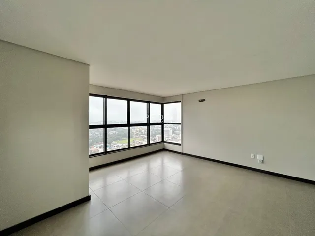 Ambiente interno amplo com grandes janelas que oferecem uma vista da cidade.