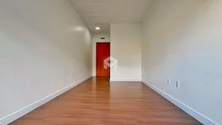 Vista de um corredor interno com piso de madeira.