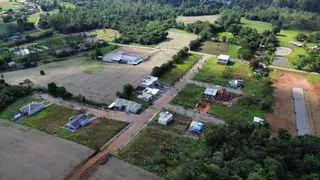 Vista aérea de uma propriedade rural com áreas de campo e construções dispersas.