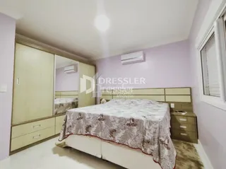Quarto com armários embutidos de madeira e cama decorada.