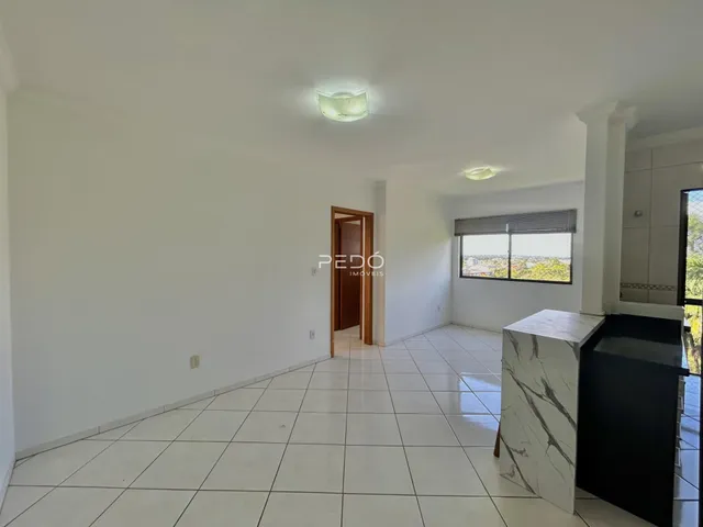 Interior de um ambiente com piso de cerâmica branca e paredes brancas.