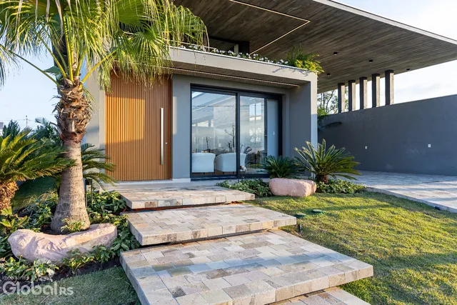 A fachada moderna de uma casa em Lajeado, Brasil, com jardim e degraus de pedra.